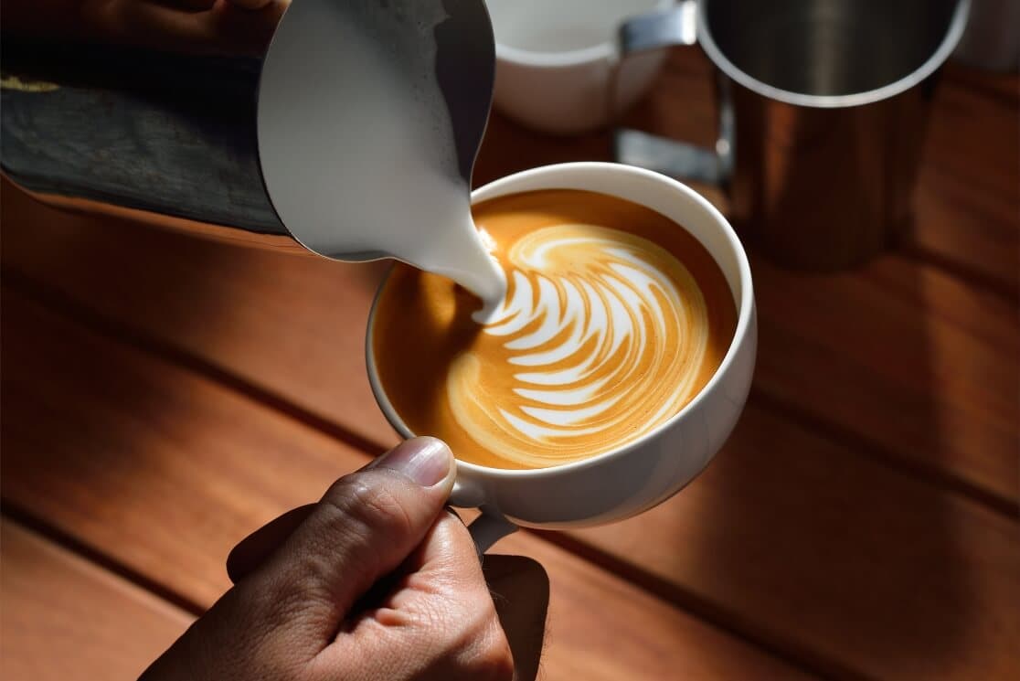 Práctica de latte art y texturización en curso de barista